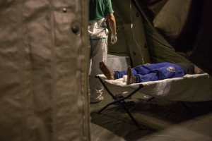A migrant in poor health is seen inside a tent of Italian Red cross after the arrival of the Norwegian ship “Siem Pilot Stavanger” with 810 refugees at Manfredi pier of Salerno port in Salerno on August 2, 2016. The ship carrying migrants coming mostly from Sudan, Nigeria, Syria and Egypt.