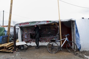 January 27, 2016 – Calais, France: A migrant is seen outside an Afghan shop in the migrants camp of Calais, known as “The Jungle”. While migrants have for years sought to cross over to Britain from Calais, the numbers have shot up since the refugee crisis went into overdrive last year.