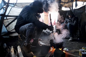 January 28, 2016 – Calais, France:  Migrants cook inside their home in the refugee camp of Calais, known as “The Jungle”. While migrants have for years sought to cross over to Britain from Calais, the numbers have shot up since the refugee crisis went into overdrive last year.