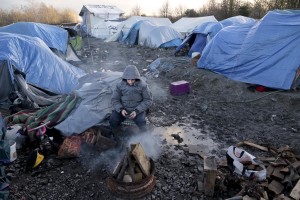 January 30, 2016 – Grande-Synthe, France: A migrant gets warm near a fire inside the refugee camp of Grande-Synthe near Dunkirk, northern France, known as “The Jungle 2″. Around 3,000 refugees and migrants of Kurdish descent from Iraq and Syria live in the camp.