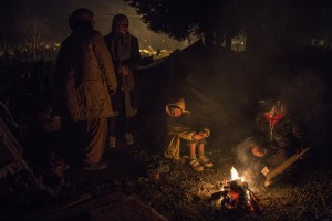 Migrants warm near a fire at refugee camp along the border of Greece and Macedonia near the town of Idomeni in Greece on March 18, 2016. The refugees are being stopped from moving beyond Greece and have been languishing in the rain, mud, and cold with insufficient food and medical care while sleeping in small tents.