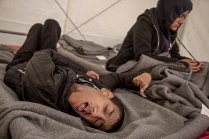 Ibrahim Nagiami, 18 years old from Aleppo, Syria is seen on his bed in a tent of the makeshift camp at the Greek-Macedonian border, near the Greek village of Idomeni where thousands of migrants are stranded by the Balkan border blockade in Idomeni, Greece on March 20, 2016. Ibrahim has mental and physical disabilities (probably he has been suffering of spastic tetraparesis) since his birth, but after the outbreak of war in Syria, his condition deteriorated because of continuous bombing, his father says.