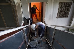 Workers wall up an apartment just abandoned by a family all inside one of the “Vele” of Scampia, to prevent the occupation of the house by new families, in Naples on November 10, 2016. The “vele” of Scampia, become famous for the long and bloody Camorra feuds, will be demolished starting from spring 2017.