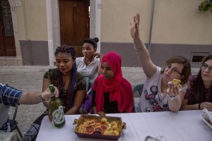 Locals and beneficiaries of the protection systems for asylum seekers and refugees are seen during a dinner organized in the center of Petruro Irpino, southern Italy on June 14, 2017. Petruro Irpino is an Italian small village with 367 inhabitants in the province of Avellino in Campania, which is claiming to be an efficient model of integration and where people of different religions and coming from different parts in the world peaceful live together.
