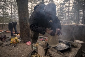 Migrant prepare food outside an abandoned building in the outskirts of the Bosnian city of Bihać, Bosnia and Herzegovina on November 28, 2018.