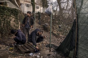 Migrants wash their shoes outside an abandoned building where they took refuge in the outskirts of the Bosnian city of Bihać, Bosnia and Herzegovina on November 29, 2018.