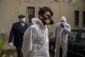 Employees of a funeral agency wear protective suits and masks during the coronavirus emergency in Naples, Italy on March 27, 2020. Although the person did not die from coronavirus, the work of funeral agency officials is among those most at risk during this emergency, as often can find in contact with corpses of people who died by coronavirus and the risk of contagion is very high.