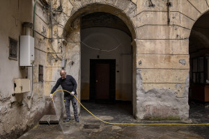 A man disinfects the courtyard of a building on the eighth day of unprecedented lockdown across of all Italy imposed to slow the spread of coronavirus in Naples, Southern Italy on March 17, 2020.