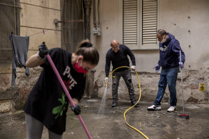 People disinfect the courtyard of a building on the eighth day of unprecedented lockdown across of all Italy imposed to slow the spread of coronavirus in Naples, Southern Italy on March 17, 2020.