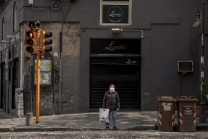 A woman wearing a mask standing at the traffic light on the eighth day of unprecedented lockdown across of all Italy imposed to slow the spread of coronavirus in Naples, Southern Italy on March 17, 2020.