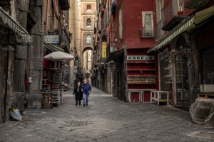 People wearing masks walk in a deserted San Gregorio Armeno street during the ninth day of unprecedented lockdown across of all Italy imposed to slow the spread of coronavirus in Naples, Southern Italy on March 18, 2020.