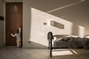 A little boy tries to open a door inside a structure managed by Piam onlus that hosts foreign girls victim of human trafficking in Asti, Northern Italy on January 12, 2020.