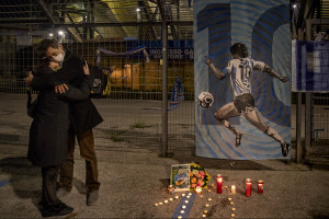 People hug each other after the death of the Argentine soccer legend Diego Armando Maradona outside San Paolo stadium in Naples, Italy on November 25, 2020.