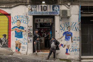 People are seen outside a bar dedicated to the Argentine soccer legend Diego Armando Maradona in the Spanish Quarter in Naples, Southern Italy on November 23, 2021. Diego Armando Maradona died on November 25 of last year and next November 25, 2021 will be the anniversary of his death.