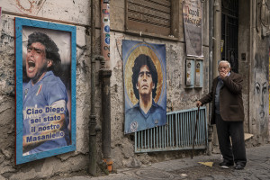 A man walks near posters and pictures depicting the Argentine soccer legend Diego Armando Maradona in the Spanish Quarter in Naples, Southern Italy on November 23, 2021. Diego Armando Maradona died on November 25 of last year and next November 25, 2021 will be the anniversary of his death.