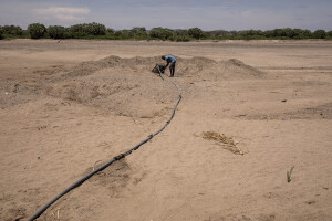 A man fetches water with a mechanical extractor from the dried Napasinyang riverbed in Kalokol, located in Turkana County, northwest Kenya on October 15, 2024. Some people have turned the severe drought that is affecting the country into a real business, selling each 20-litre water tank for 5 Kenyan shillings. However, the water that they fetch from the underground, is not clean and often causes infections or diseases.