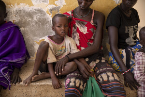 Kevin, 4 years old suffering from malaria is seen with his mother Elisabeth outside the Kangatosa Health Centre located in Turkana County, northwest Kenya on October 19, 2024. Children often go fetching water with their mothers in areas where stagnant pools of water form and mosquitoes that carry the malaria parasite proliferate. Over the past three years Kenya has suffered from intense drought, partly caused by global warming, which also provides favourable conditions for the development of these mosquitoes.