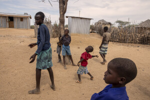 A child throws a stone to retrieve a ball stuck in the branches of a tree in Kapua village, located in Turkana County, northwest Kenya on October 17, 2024. Kapua is one of the villages most affected by the severe drought in Kenya, that is generating food insecurity and difficult access to water. Many people are forced to drink water that they fetch from the underground, which is not clean and often causes infections or diseases.