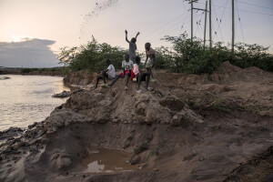 Children play with mud on the bank of the dried Kawalasee River in Lodwar, northwest Kenya on October 19, 2024. Kenya’s rivers are drying up rapidly, with low rainfall and global warming being among the main causes of this phenomenon.