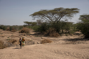 Two women walk near the dried Kalotumum riverbed, before starting to fetche water in Kerio, located in Turkana County, northwest Kenya on October 15, 2024. Due to the severe drought that is affecting the country, many people are forced to drink water that they fetch from the underground, which is not clean and often causes infections or diseases.