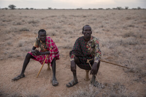 Natagor (left) and his brother Nataluc (right) sit on their ekicholong, a traditional stool that is specifically owned by turkana men in the Katapokori village, northwest Kenya on October 16, 2024. Due to the severe drought that is affecting the country, lots of the animals that Natagor and Nataluc owned have died.