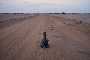 A child sits on the street in the Katapokori village, northwest Kenya on October 16, 2024. Katapokori is one of the villages most affected by the severe drought in Kenya, that is generating food insecurity and difficult access to water. Many people are forced to drink water that they fetch from the underground, which is not clean and often causes infections or diseases.